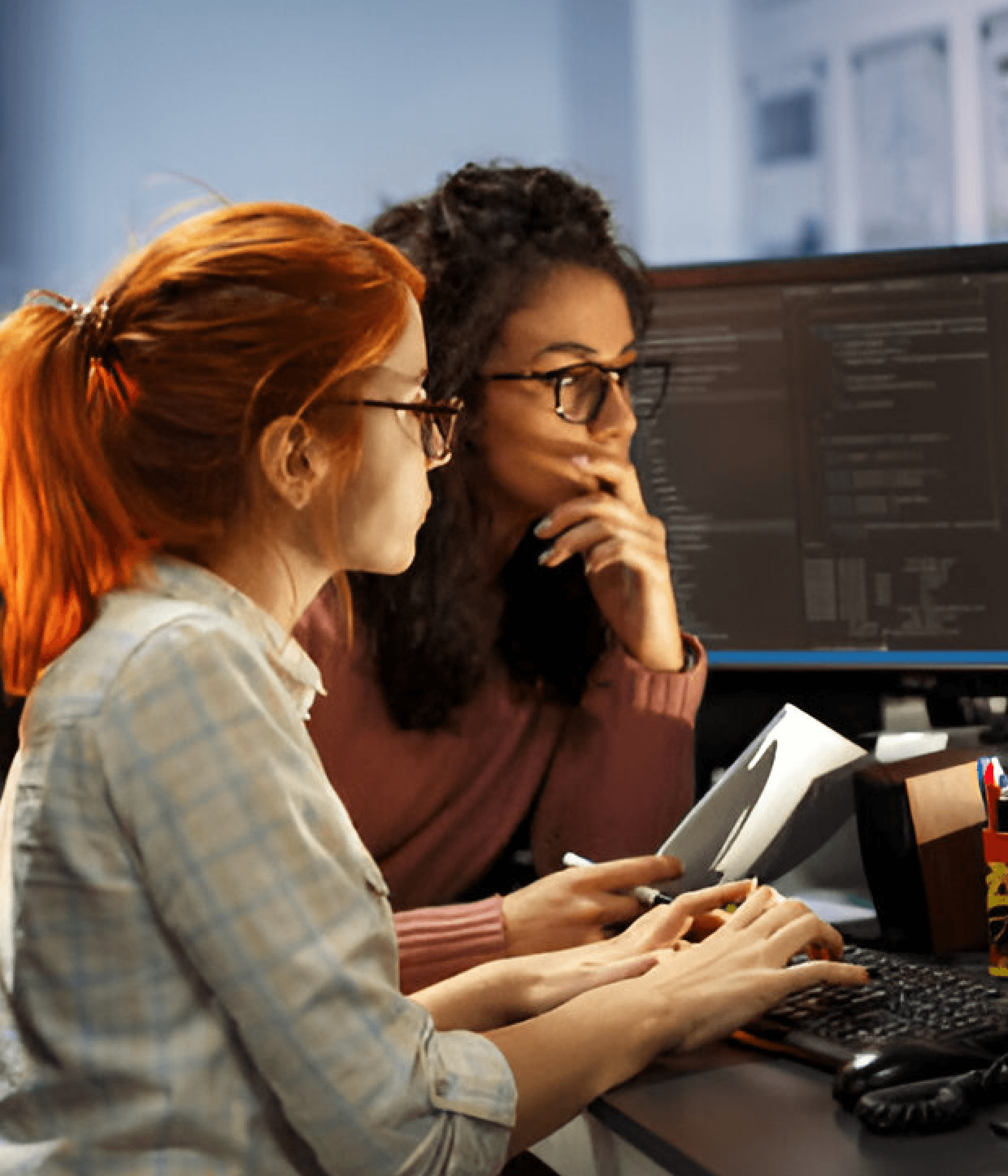 Two people writing code on a pc