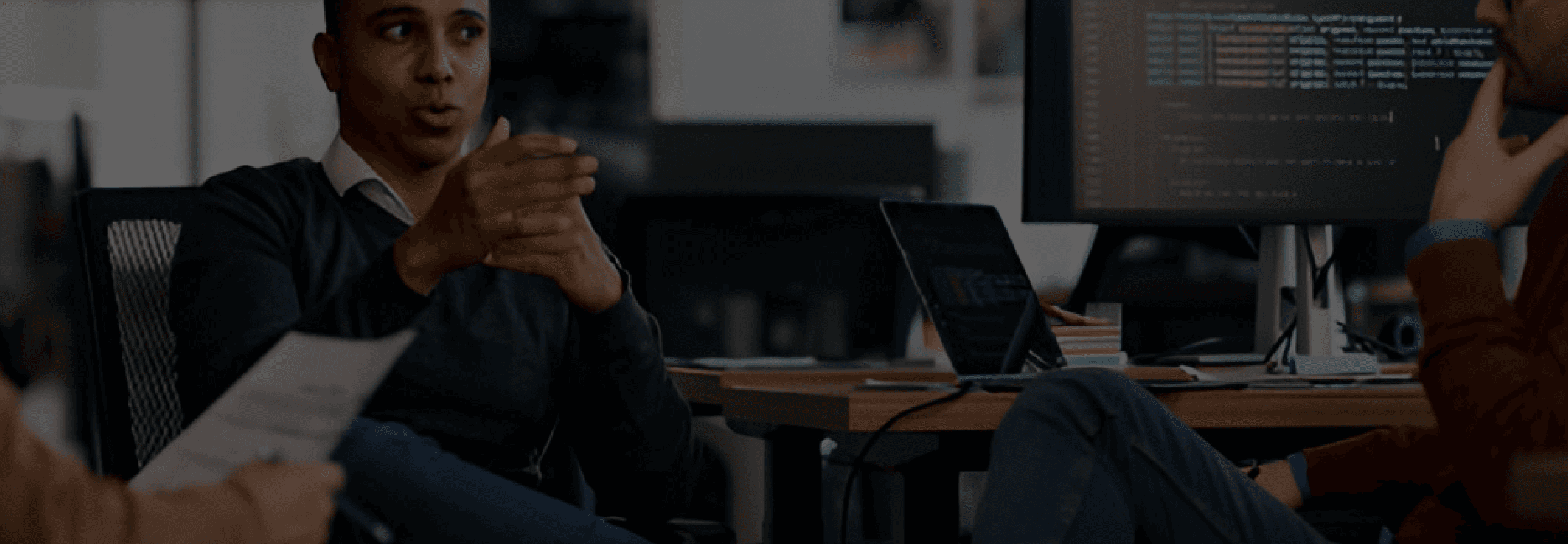 Team in a meeting with code on screen